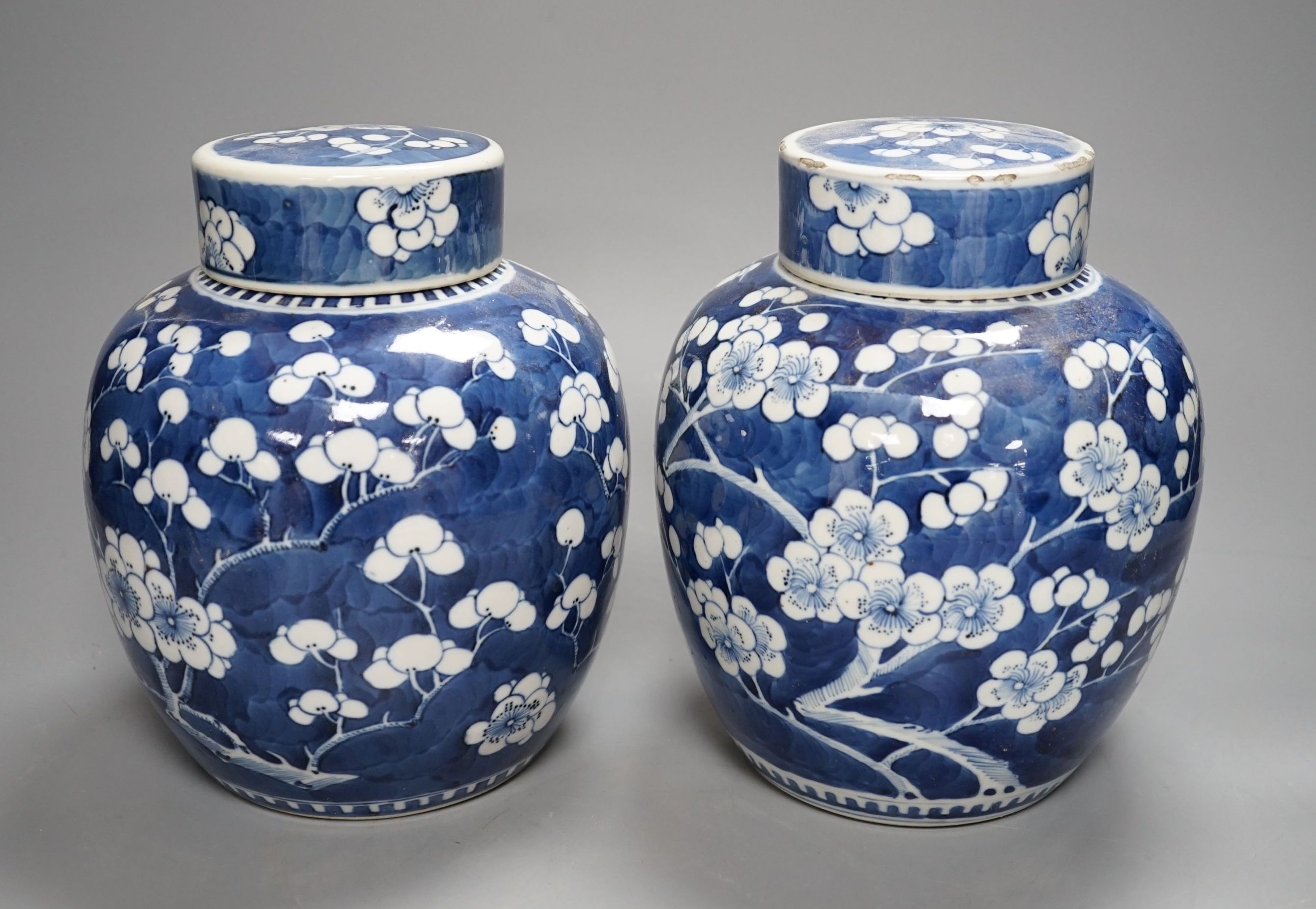 A pair of Chinese blue and white ginger jars and covers, 22 cms high including cover.